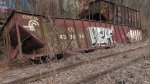 An old Conrail hopper lies along the hillside